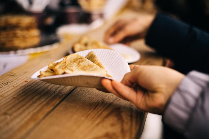 A person holding a crepe on a plate